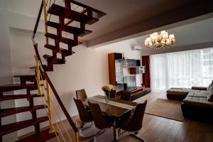 a living room with a dining table and a spiral staircase at Elite Apartments Sinaia in Sinaia