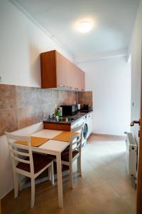 a kitchen with a table and a sink and a stove at Elite Apartments Sinaia in Sinaia