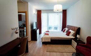 a bedroom with a bed and a large window at Elite Apartments Sinaia in Sinaia