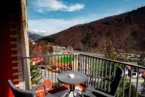a balcony with a table and chairs and a view at Elite Apartments Sinaia in Sinaia