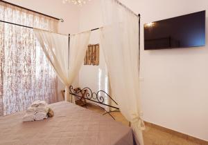1 dormitorio con 1 cama con cortina y TV en Casa Porta Marina, en Ventimiglia