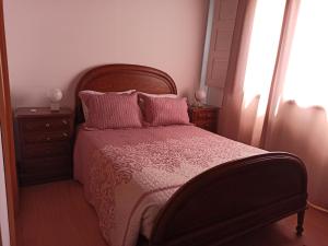 a bedroom with a bed with pink sheets and pillows at Casa da Granja in Arouca