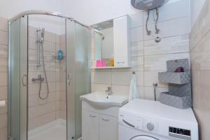 a bathroom with a shower sink and a washing machine at Apartment Ana in Pula