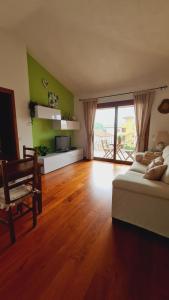 un soggiorno con letto e pavimento in legno di La Coccinella a Olbia