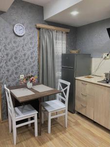 uma cozinha com uma mesa e cadeiras e um frigorífico em Eka's House em Tbilisi