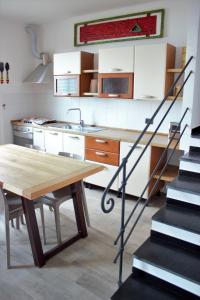 a kitchen with a wooden table and a staircase at Azalea in Recco