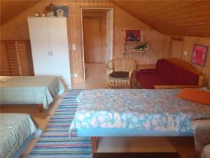 a bedroom with two beds and a couch at Karvisen Kissanpäivät Joensuun lähellä in Ruokola