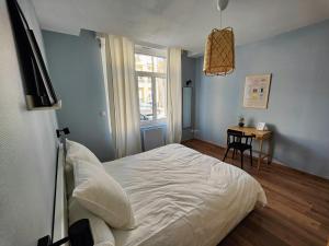 une chambre avec un lit, une table et une fenêtre dans l'établissement Le Bienvenu - T2 avec terrasse au coeur de Malo, à Dunkerque
