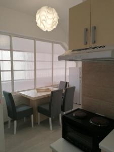 a kitchen with a table and chairs and aendant light at Apartman Andrijana 1 in Soko Banja