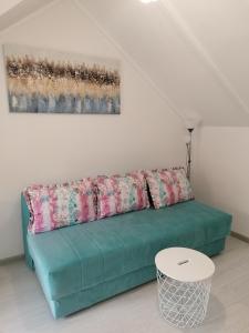 a green couch in a living room with a painting at Apartman Andrijana 1 in Soko Banja