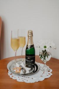 a bottle of champagne and two glasses on a table at Hotel U Lípy in Hřensko
