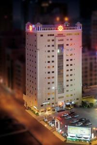 um grande edifício branco com carros estacionados em frente em Al Safir Tower - Residence em Juffair