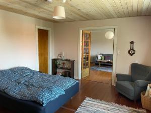 um quarto com uma cama, um sofá e uma cadeira em Retro bolig - fyldt med hygge! Ingen luksus em Kolind