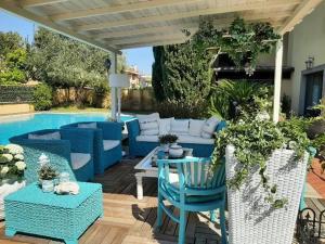 un patio con muebles azules junto a una piscina en B&B Le Lanterne en Casal Palocco
