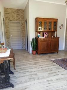 een woonkamer met een tafel en een houten kast bij B&B Casa Delfina in Capoterra