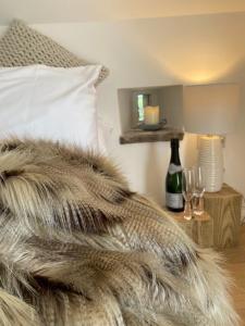 a bedroom with a bed with a pillow and a table with wine glasses at Little Barn Peak District in Leek