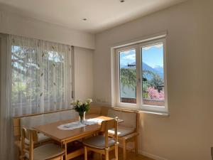 a dining room with a table and two windows at Naif-Home in Merano