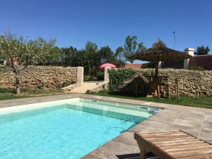 einen Pool mit einem Tisch und einem Sonnenschirm in der Unterkunft Le jardin secret bnb in Villeneuve-lès-Béziers