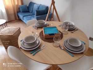 Malpica Nordic Home في مالبيسا: طاولة خشبية عليها لوحات واكواب للنبيذ