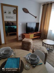 sala de estar con mesa y TV en Malpica Nordic Home, en Malpica de Bergantiños