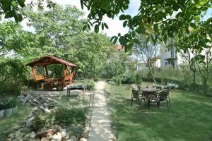 a garden with a table and chairs and a gazebo at Holiday House Costinesti in Costinesti