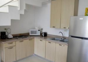 uma cozinha com um frigorífico branco e um lavatório em BAVARO PUNTA CANA Apartamento con Piscina em Punta Cana