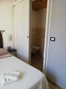 een slaapkamer met een bed en een badkamer met een toilet bij B&B Casa Delfina in Capoterra