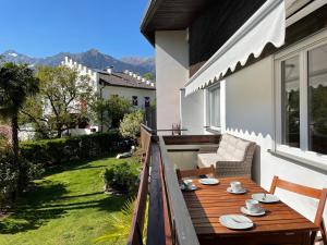 a wooden deck with a table and chairs on a house at Naif-Home in Merano