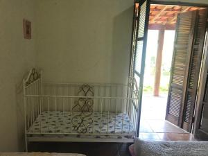 a white crib in a room with an open door at CHÁCARA GODOI - Meu Paraíso in Itu +51 photos