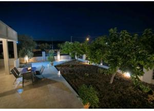 a patio with a table and chairs at night at AMMOS in Salamina