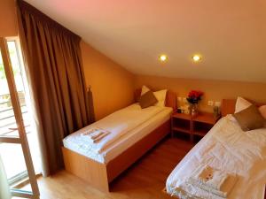 a hotel room with two beds and a window at Vila di Pau in Băile Herculane +31 photos