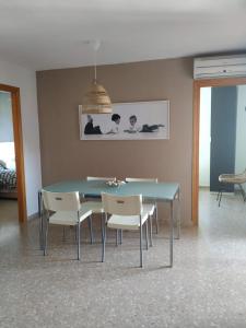 jadalnia z niebieskim stołem i białymi krzesłami w obiekcie Apartamento Con Preciosas Vistas Al Mar,WIFI y piscina de temporada w mieście Canet de Berenguer