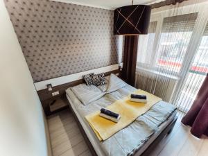 1 dormitorio con 1 cama con 2 toallas en Holiday Apartman en Sárvár