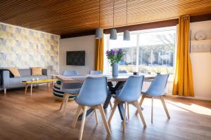 a dining room with a table and blue chairs at Elli´s Hus in Loit