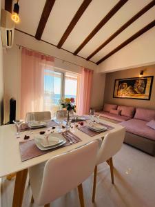 a dining room with a table and a couch at Apartment Mare in Rab
