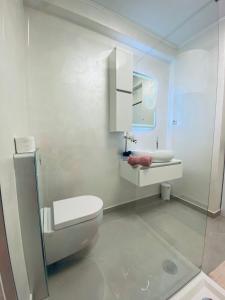 a white bathroom with a toilet and a sink at Apartment Mare in Rab +36 photos