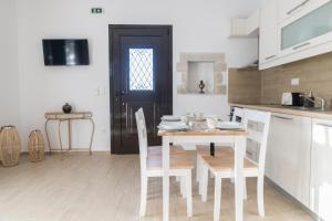 cocina con mesa, sillas y puerta en Villa Mira, en Kamilari