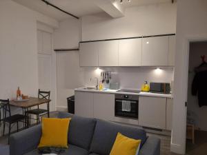 a living room with a couch and a kitchen at Eastgate Hideaway - central, luxury apartment on Chester's historic rows in Chester