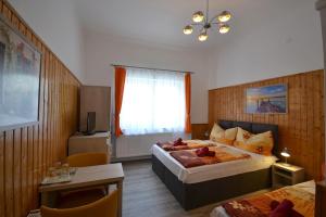 Cette chambre comprend 2 lits et une table. dans l'établissement Guest House Silatti, à Keszthely