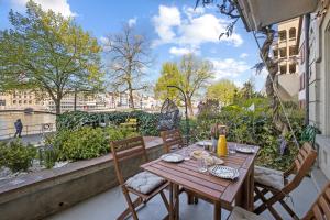 a wooden table and chairs on a balcony with a view at True Basel - Zentral I Terrasse mit Rheinblick in Basel