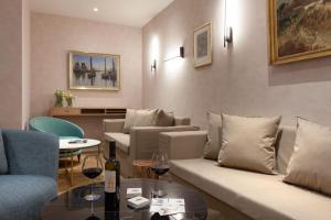 a living room with couches and a table with wine glasses at Vju Hotel Rügen in Göhren