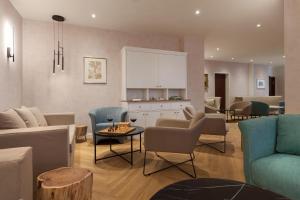a living room with a couch and chairs and a table at Vju Hotel Rügen in Göhren