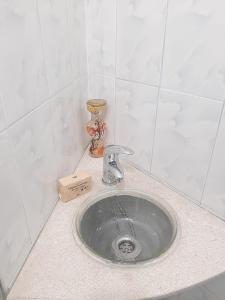 a sink in a bathroom with aaucet on a counter at Vrenjo GuestHouse in Gjirokastër +36 photos