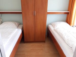 two beds and a cabinet in a room at Duinweg 35 in Westkapelle