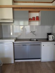 a kitchen with white cabinets and a sink at Duinweg 35 in Westkapelle
