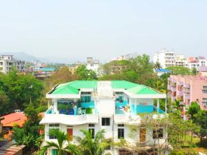 a large white house with a green roof at Cupidtrails Backpacker's Penthouse in Guwahati