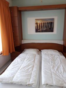 a bed in a bedroom with a painting on the wall at Duinweg 35 in Westkapelle