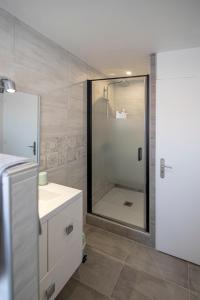 y baño con ducha, lavabo blanco y ducha. en T2 3 étoiles de charme 40 m2 centre ville Dax, en Dax