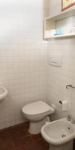 a white bathroom with a toilet and a sink at La Rocca delle Pigne in Cana