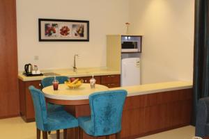een keuken met een tafel en een koelkast bij بيستانا للشقق الفندقية 2 in Riyad